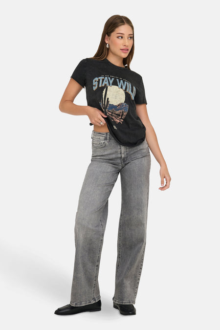 Zwart T-shirt met korte mouwen van ONLY®, met grafische print en gedragen met een grijze high-waist jeans en zwarte loafers.