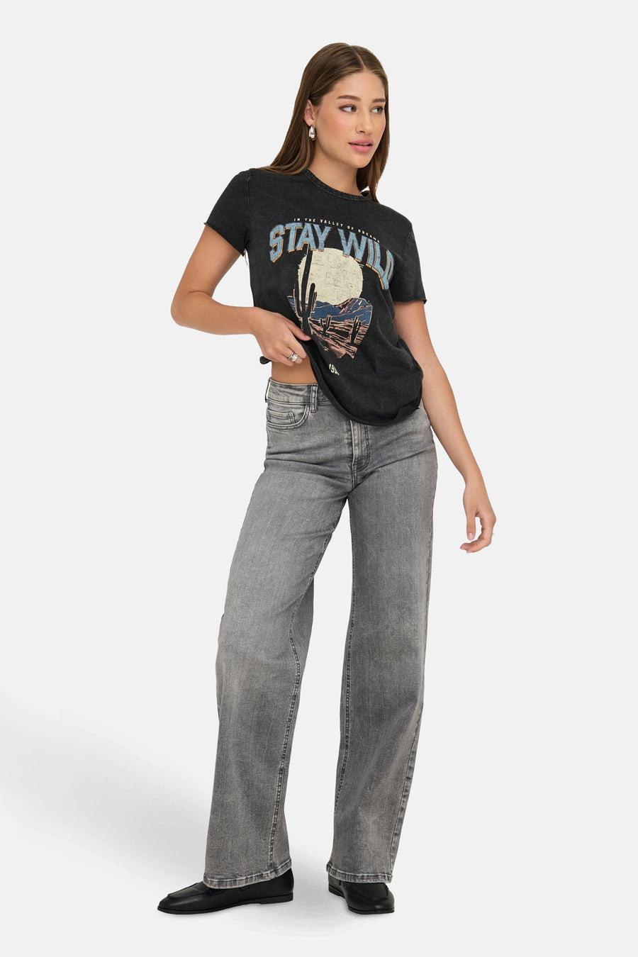 Zwart T-shirt met korte mouwen van ONLY®, met grafische print en gedragen met een grijze high-waist jeans en zwarte loafers.