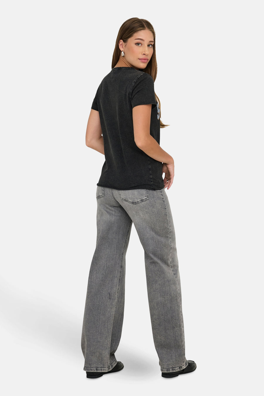 Zwart T-shirt met korte mouwen van ONLY, gedragen met een grijze flared jeans en zwarte loafers.