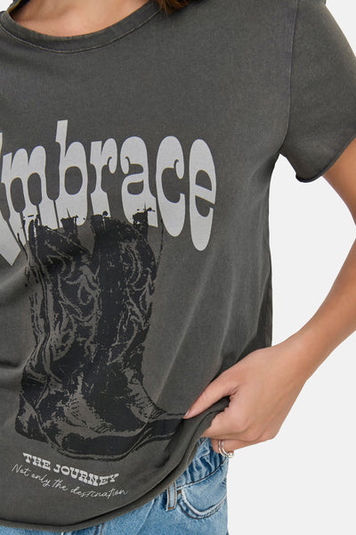 T-shirt à manches courtes gris de ONLY, avec un imprimé de botte de cowboy et le mot « embrace » en blanc.