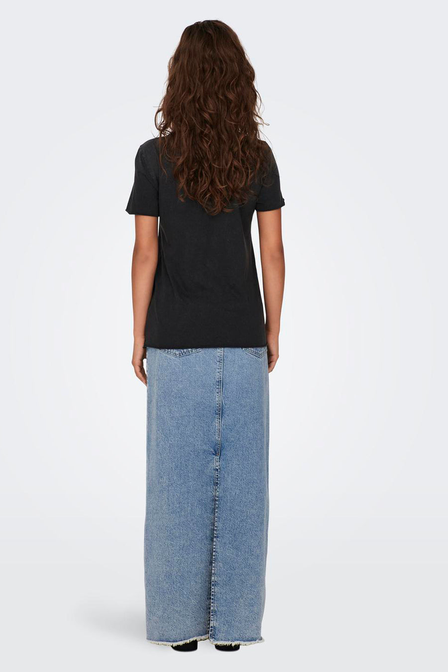 Zwart T-shirt met korte mouwen van ONLY, gedragen met een lange, uitgewassen spijkerrok.