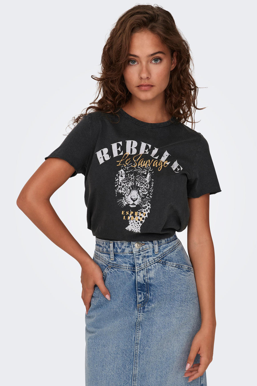 Zwart T-shirt met korte mouwen van ONLY®, met luipaardprint en opschrift "Rebel Le Sauvage", gedragen met een spijkerrok.