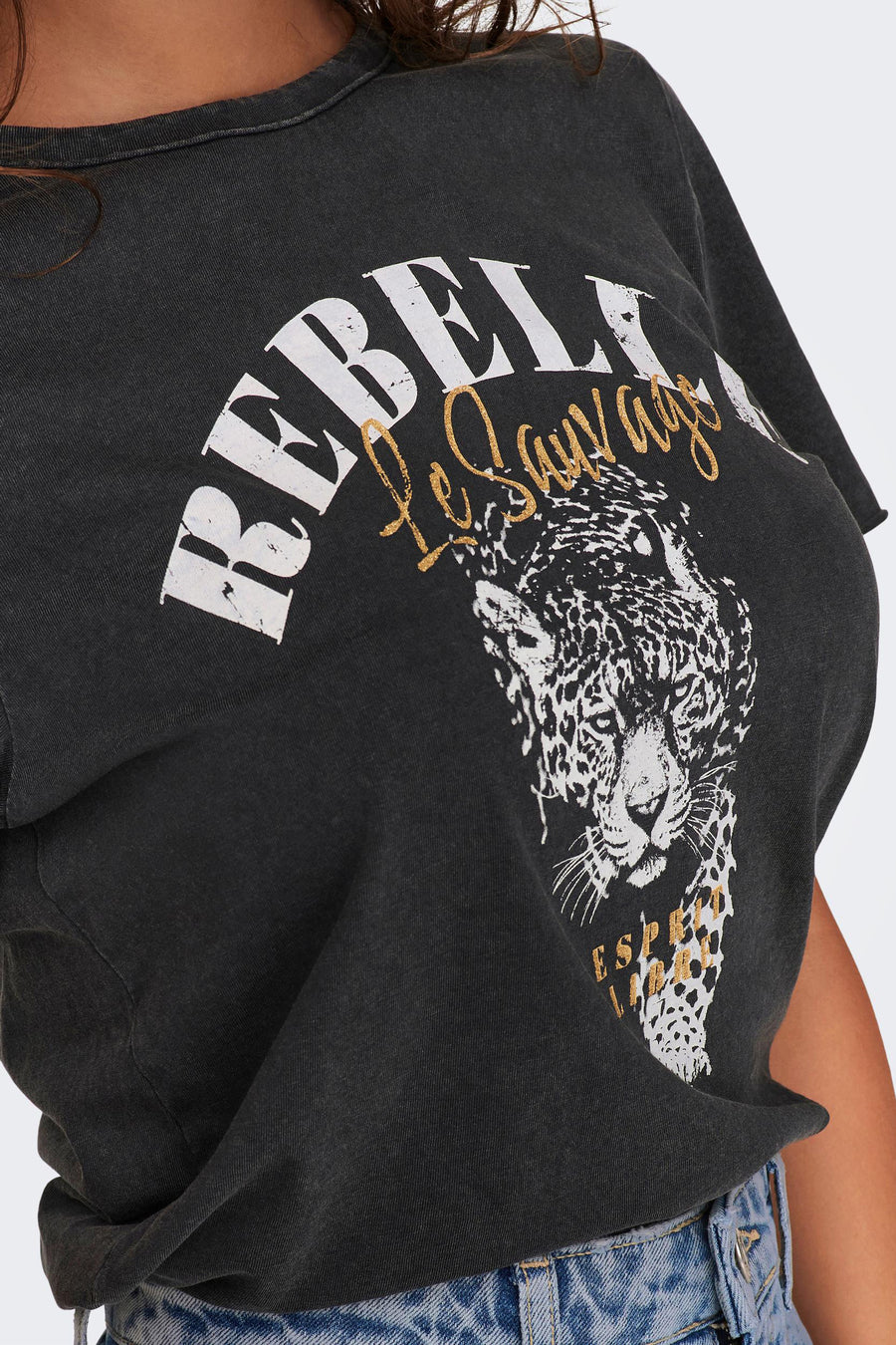 Zwart T-shirt met luipaardprint van ONLY, met witte en gouden decoratieve letters, gedragen met een high-waisted jeans.