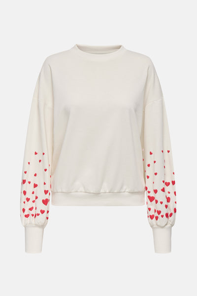 Sweat-shirt écru col rond de ONLY, avec des motifs de cœurs rouges sur les manches bouffantes.
