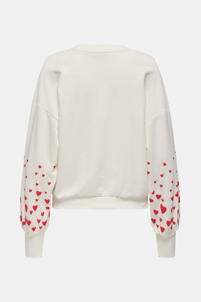 Sweat écru de ONLY® avec des motifs de cœurs rouges sur les manches.
