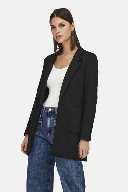 Zwarte blazer van ONLY, gedragen over een witte tanktop en een wijde spijkerbroek.