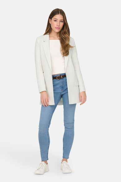 Blazer beige de ONLY, porté sur un pull et un jean avec une ceinture marron.