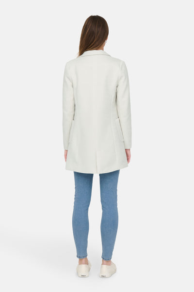 Blazer beige par ONLY, porté avec un jean bleu et des chaussures de sport crème, vue de dos.
