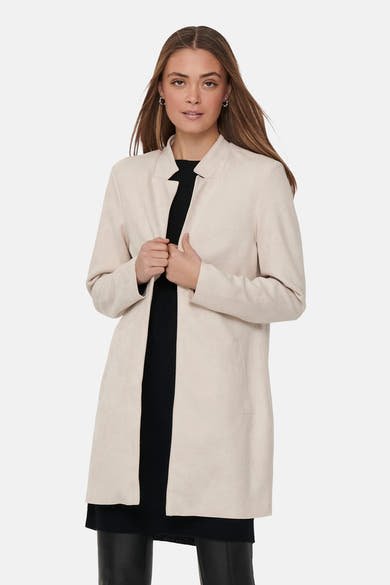 Lange beige jas van ONLY, gedragen over een zwarte jurk, met zilveren oorbellen.