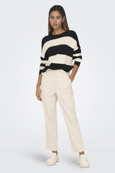 Pull à rayures noir et beige de ONLY, porté avec un pantalon beige et des chaussures assorties.
