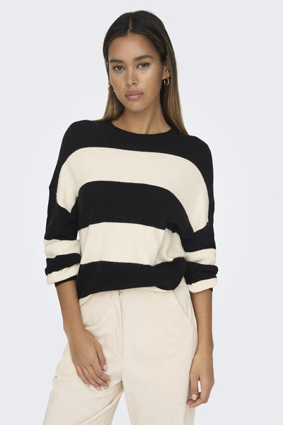 Pull noir à rayures by ONLY, porté avec un pantalon beige.