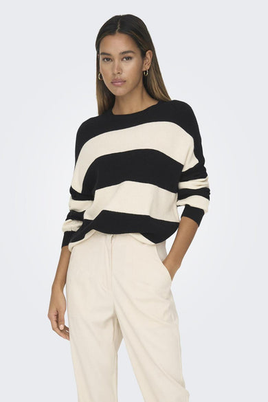 Pull noir rayé par ONLY, porté avec un pantalon beige taille haute.
