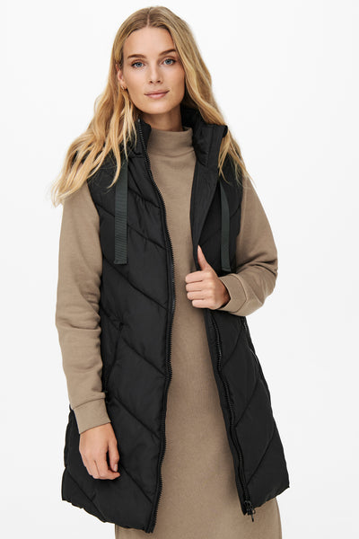 Bodywarmer noir by JDY, portée sur une robe à col roulé beige, avec capuche.