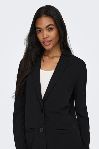Blazer noir de JDY porté sur un haut blanc, avec une coupe ajustée et boutonnée.

