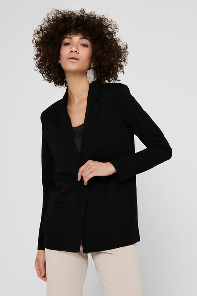 Blazer noir de JDY avec une coupe classique, porté sur un haut noir uni et un pantalon beige.