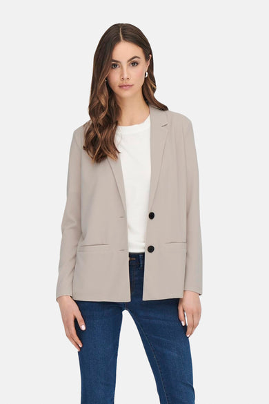 Beige blazer van JDY, gedragen over een wit T-shirt en een blauwe jeans.