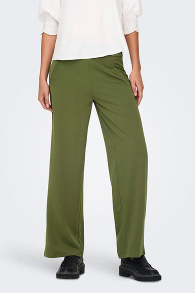 Pantalon de costume kaki de JDY, coupe large, porté avec un chemisier blanc à manches courtes.
