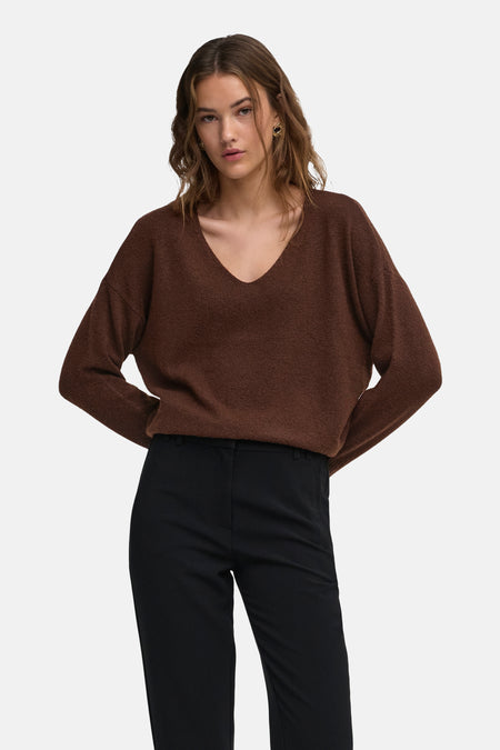 Pull col V marron foncé de style oversize par ONLY®, en maille douce, porté avec un pantalon noir, vue frontale.