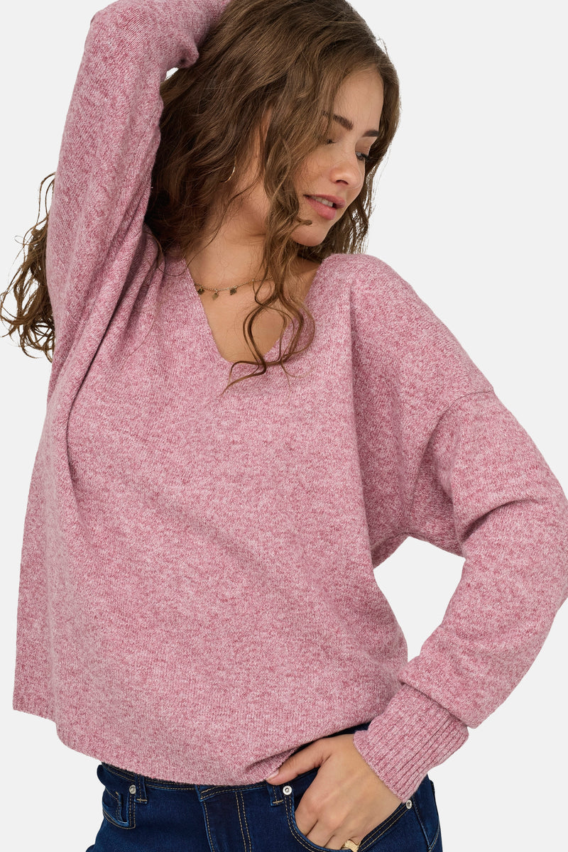 Pull à col en V rose de ONLY, porté avec un collier doré et un jean foncé.