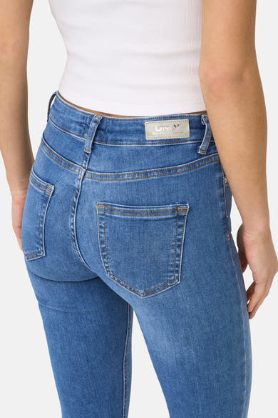 Blauwe skinny jeans van ONLY, met achterzakken en zichtbare naden, gedragen met een witte top.