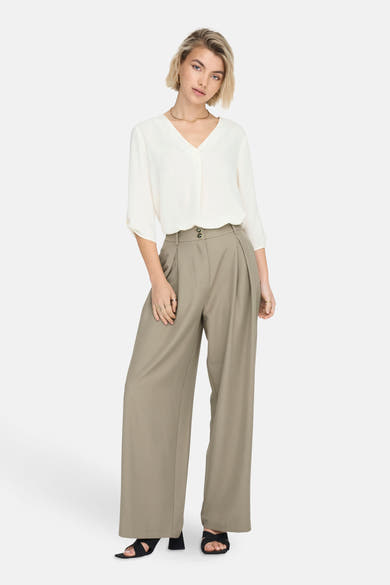 Wit 3/4-mouwen blouse van JDY, gedragen met een broek met hoge taille en sandalen met hak.