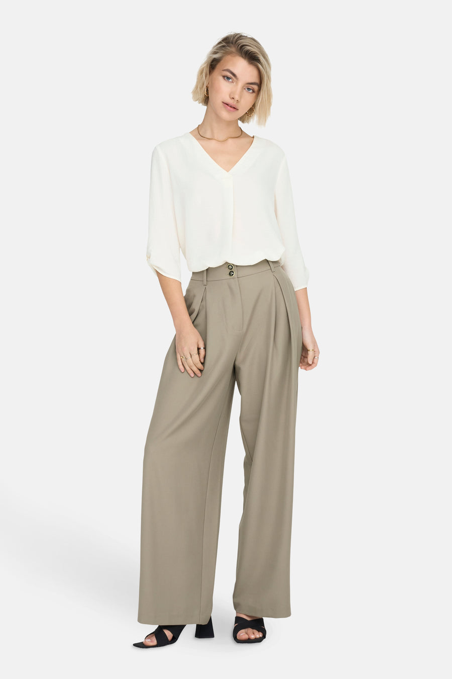 Wit 3/4-mouwen blouse van JDY, gedragen met een broek met hoge taille en sandalen met hak.