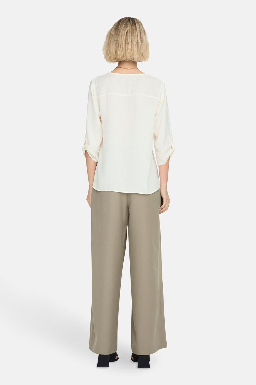 Wit 3/4-blouse van JDY met opgerolde mouwen en een rechte pasvorm, gedragen met een wijde beige broek.
