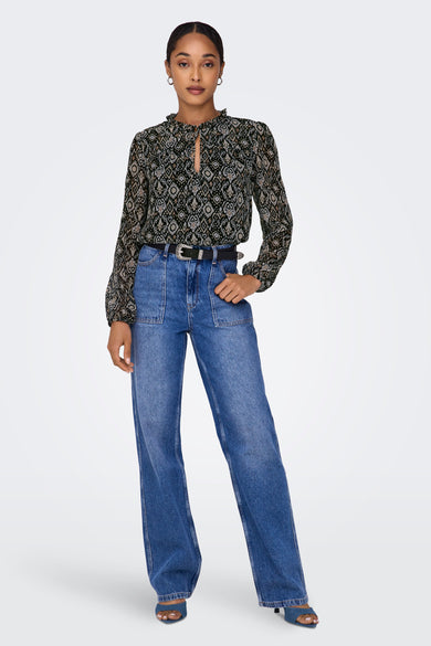 Blouse à manches longues multicolore de ONLY, avec un motif imprimé et un col volanté, portée avec un jean taille haute et une ceinture noire.
