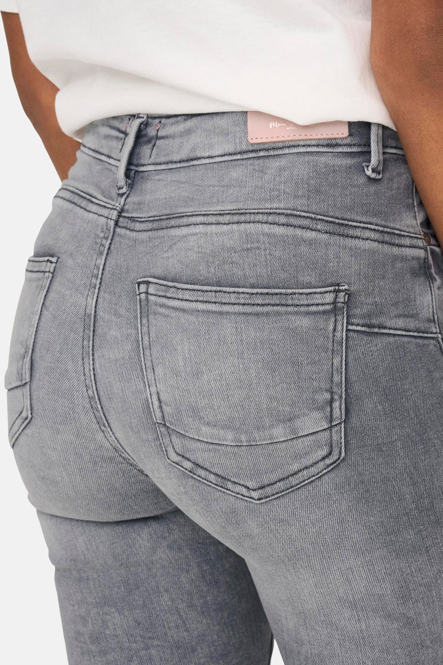 Lichtgrijze skinny jeans van ONLY, achterzakdetail, gedragen met een wit T-shirt.