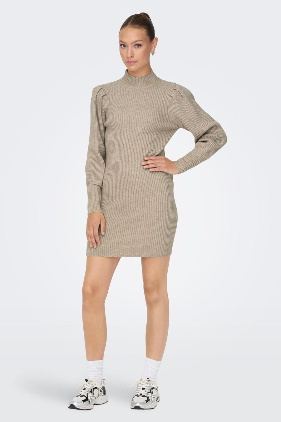 Robe courte beige de ONLY, avec des manches longues bouffantes et une texture côtelée, portée avec des chaussures de sport blanches.

