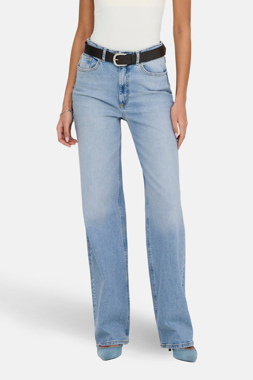 Jean large en denim bleu clair de ONLY, avec ceinture noire et chaussures assorties.