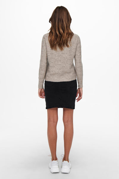 Pull beige col rond de ONLY®, avec motif ajouré et manches longues, porté avec une jupe noire et des baskets blanches.