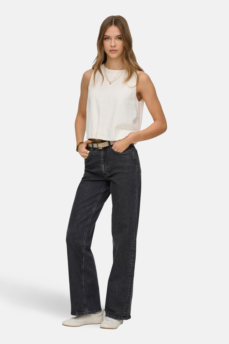 Jean large gris par ONLY, porté avec un top blanc sans manches, une ceinture dorée et des chaussures blanches.
