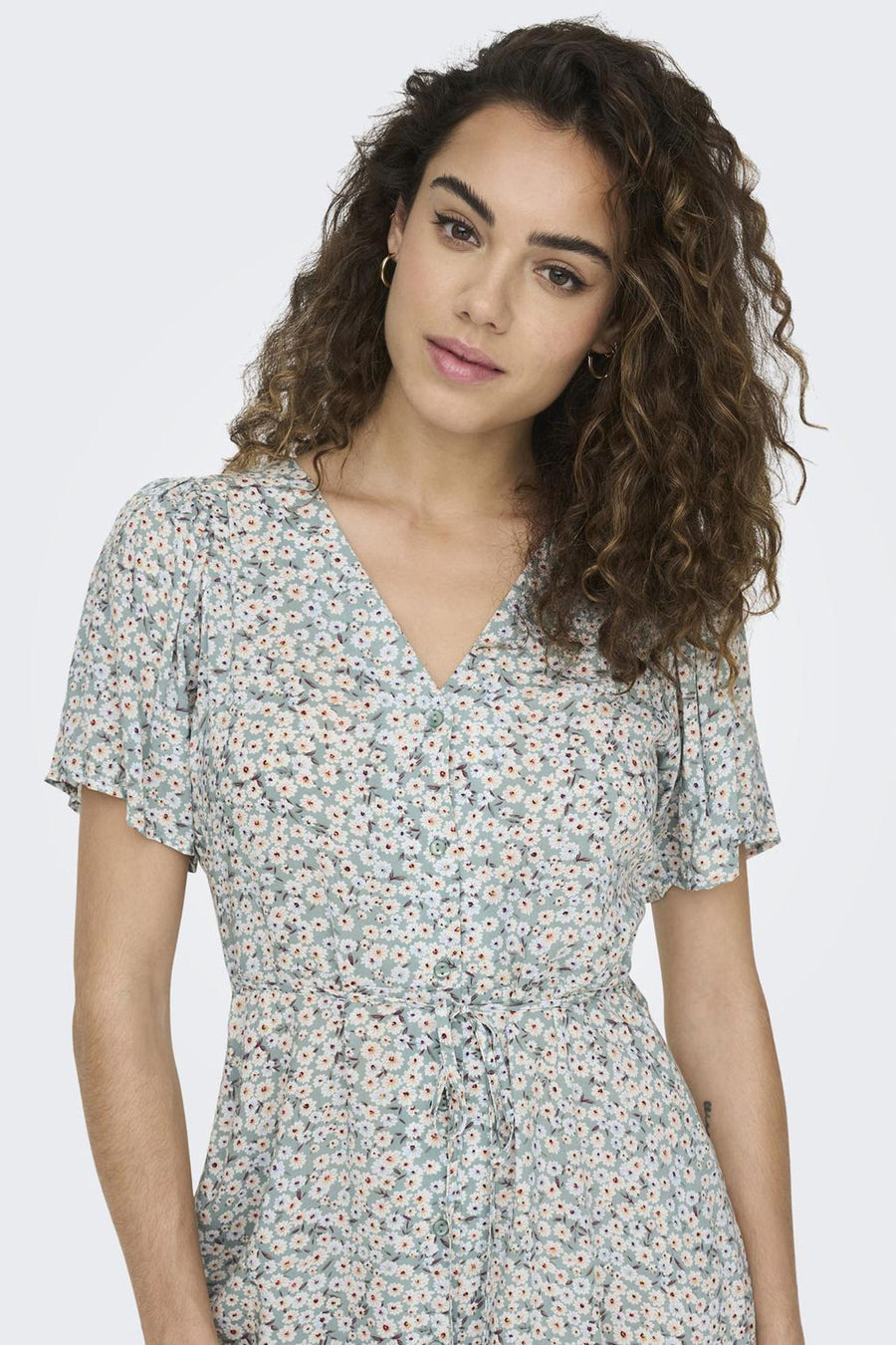 Groene jurk met korte mouwen van ONLY met wit bloemenpatroon, V-hals en strikdetail in de taille.
