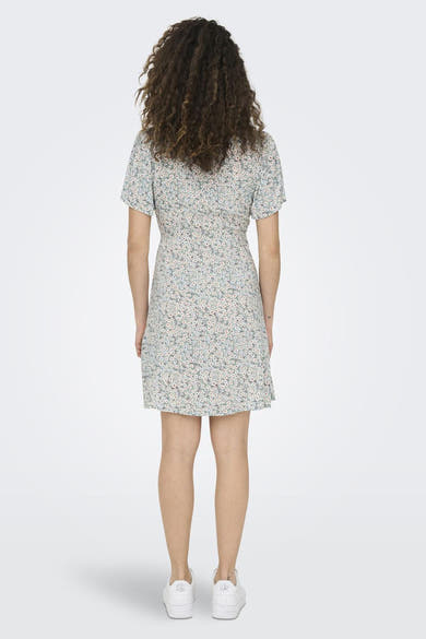 Groene jurk met korte mouwen en bloemenprint van ONLY®, van achteren gezien, gedragen met witte sneakers.
