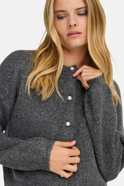 Cardigan gris de ONLY, avec boutons nacrés et texture tricotée portée par un mannequin blond.

