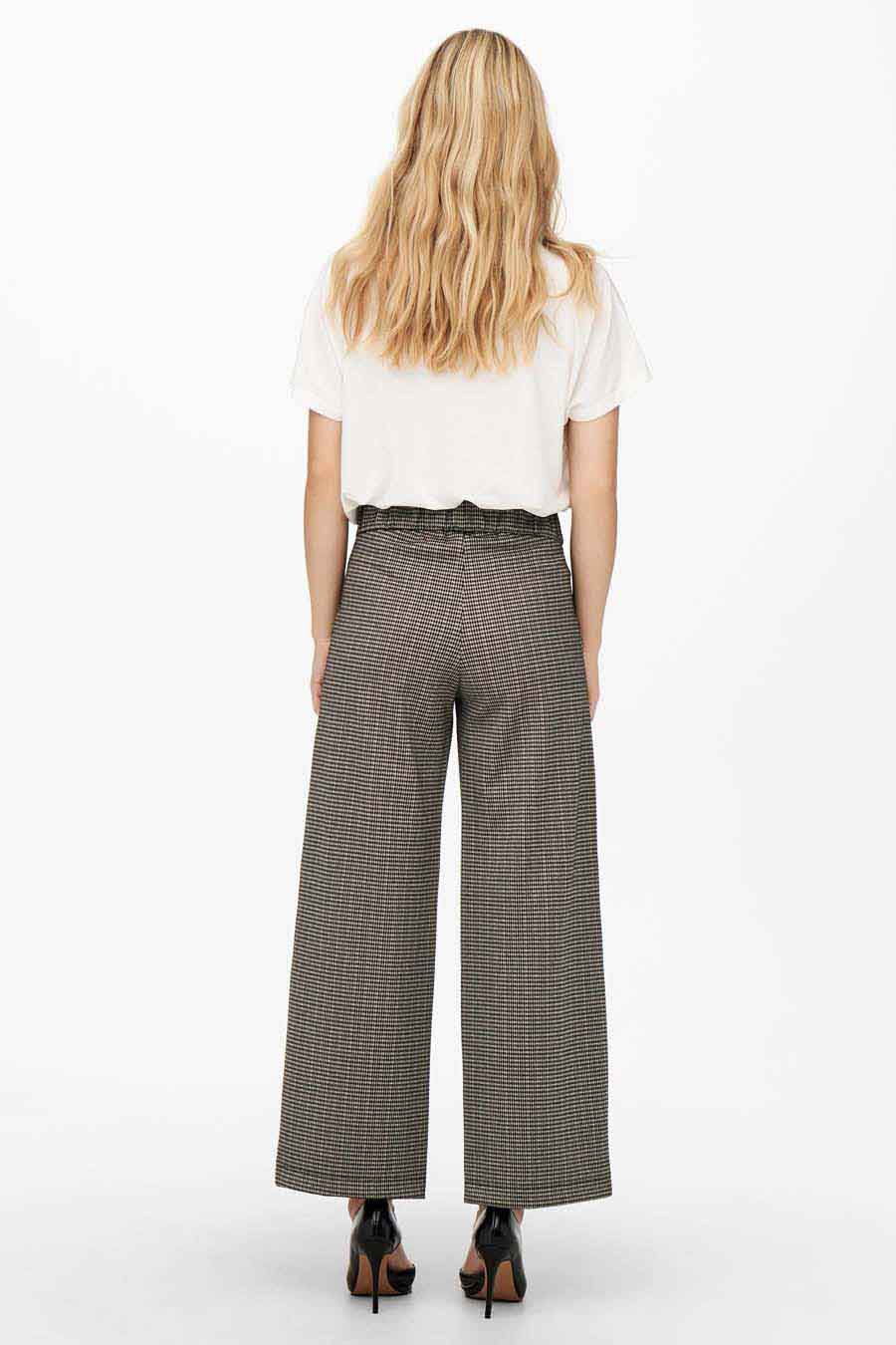 Pantalon large à carreaux gris de JDY, porté avec un t-shirt blanc et des escarpins noirs, vue de dos.
