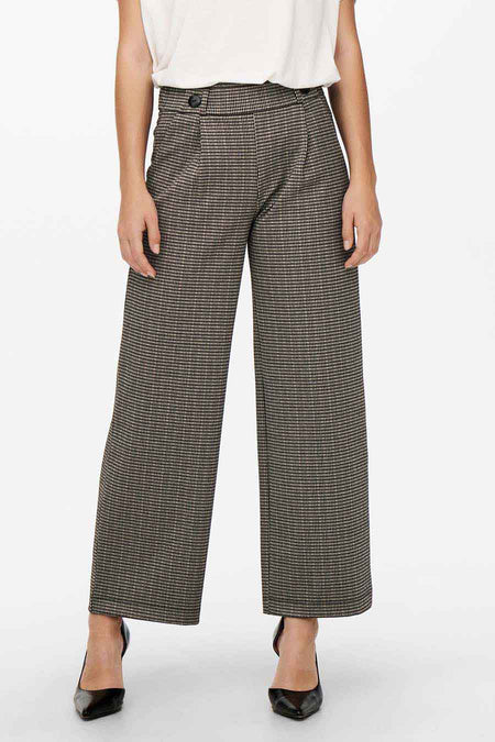 Grijze geruite broek van JDY, wijde pasvorm, met een beige top en zwarte hakken.