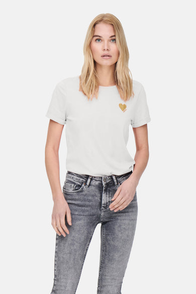 Wit T-shirt met korte mouwen van ONLY, versierd met een glinsterend gouden hart op de borst, gedragen met een grijze jeans.