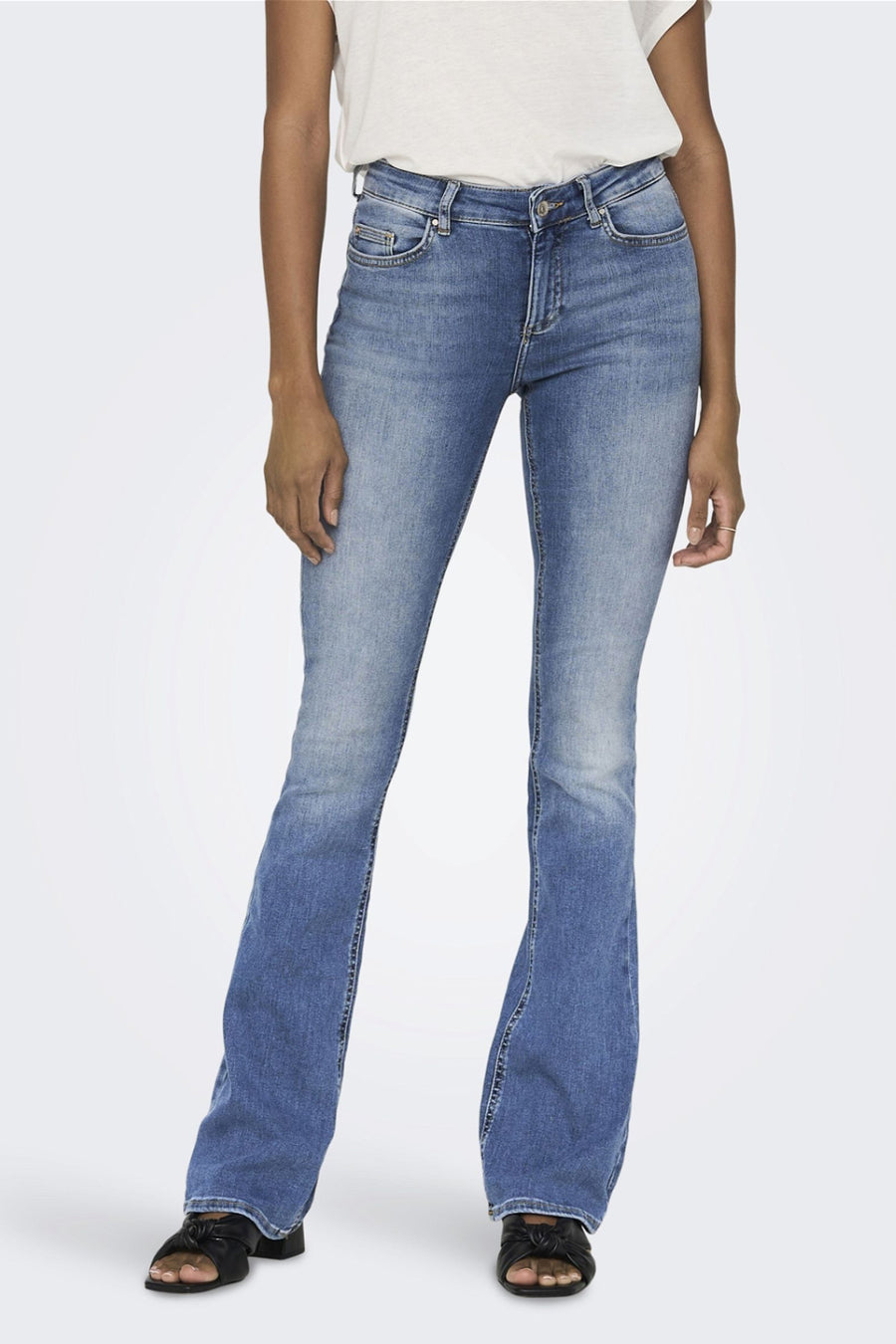 Wijd uitlopende jeans van lichtblauw denim van ONLY®, gedragen met zwarte sandalen.