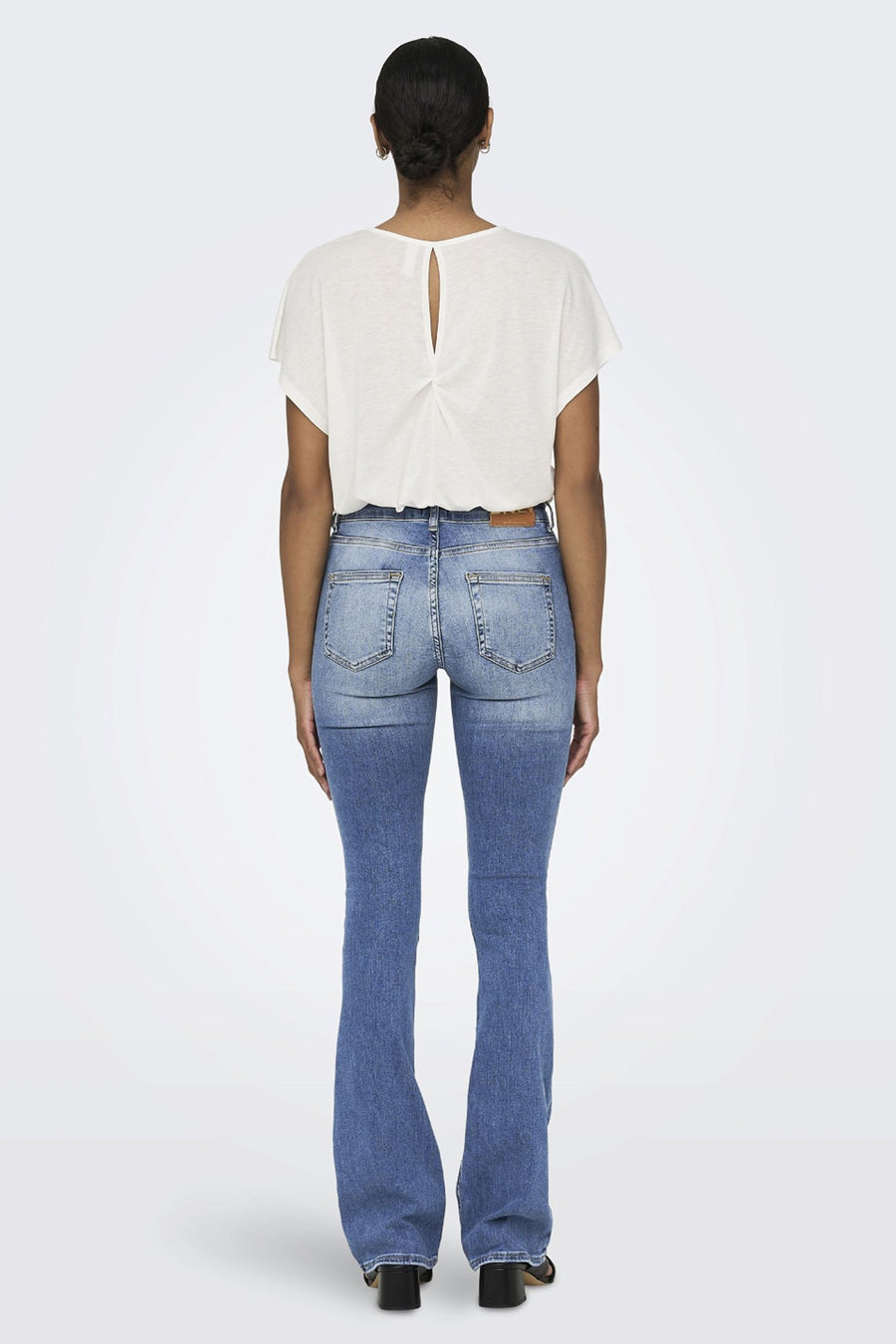 Jean évasé en denim bleu clair de ONLY, avec délavage sur le haut et ourlet sur chaussures à talons.