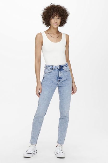Jeans mom bleu clair de ONLY, portés avec un débardeur blanc et des baskets compensées.