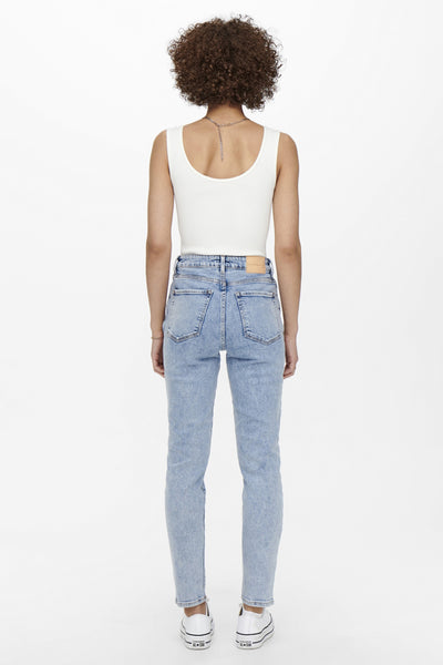 Jean Mom bleu clair de ONLY, porté avec un débardeur blanc et des chaussures Converse blanches.