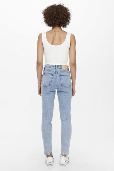 Jean mom blauw van ONLY, gedragen met een witte tanktop en witte sportshoes.