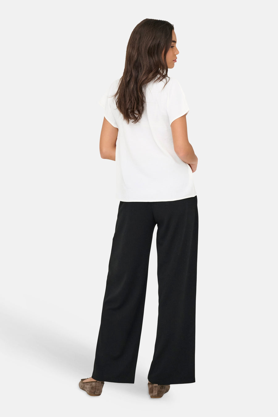 JDY wit blouse met korte mouwen, losse pasvorm, van achteren gedragen met een zwarte broek en platte schoenen.