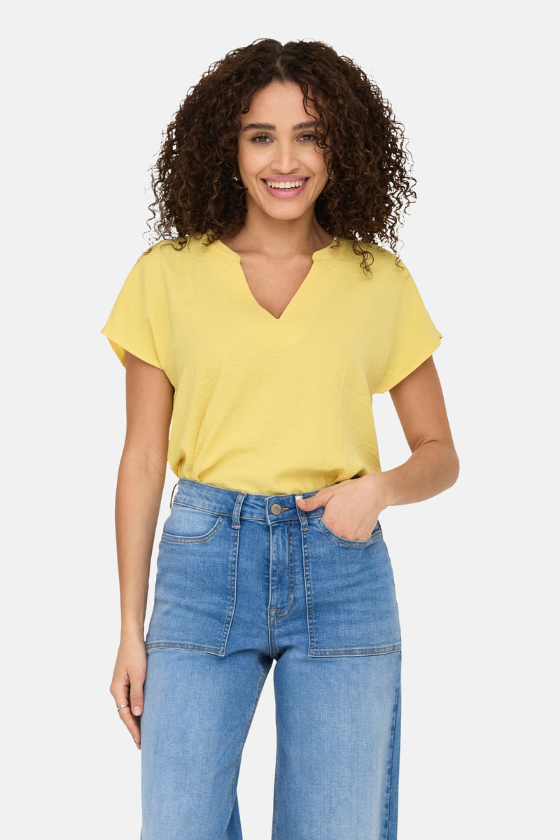Gele blouse met korte mouwen van JDY, gedragen met een high-waisted spijkerbroek, effen.