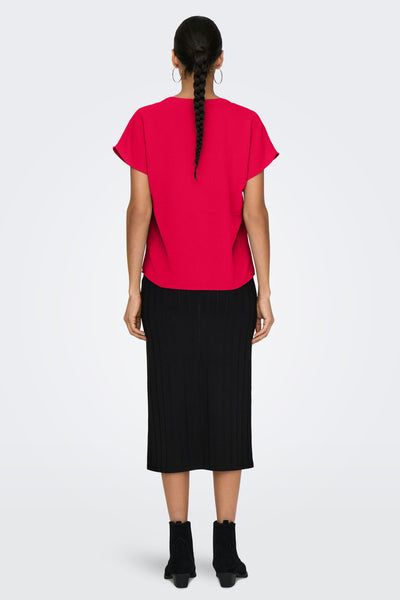 Rood shirt met korte mouwen van JDY, met een krans in de rug, gedragen met een zwarte rok en laarzen.