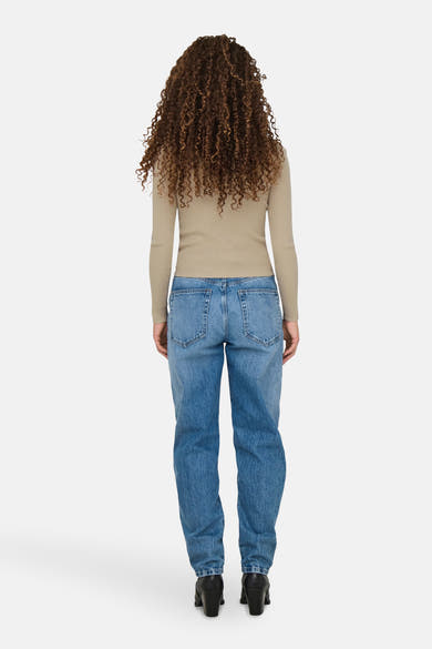 Beige trui met ronde hals van JDY, gedragen met een blauwe jeans en zwarte enkellaarsjes met hak.