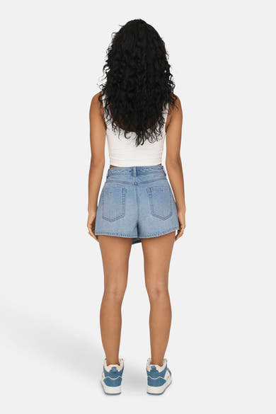 Short en denim bleu clair de ONLY, porté avec un haut blanc et des baskets.