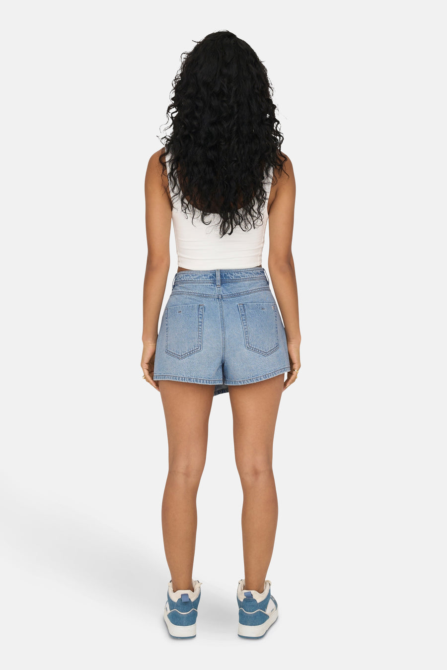 Short en denim bleu clair de ONLY, porté avec un haut blanc et des baskets.